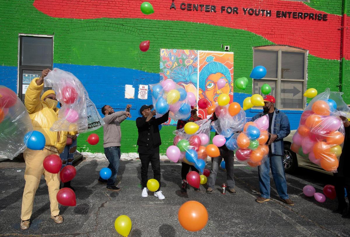 Linda Brown, left, Juan Tabbs, executive director of Arts Tech, Ron Hunt and others released balloons in remembrance of the homicide victims of 2021 at ArtsTech in Kansas City, Missouri, on Friday, Dec. 31.