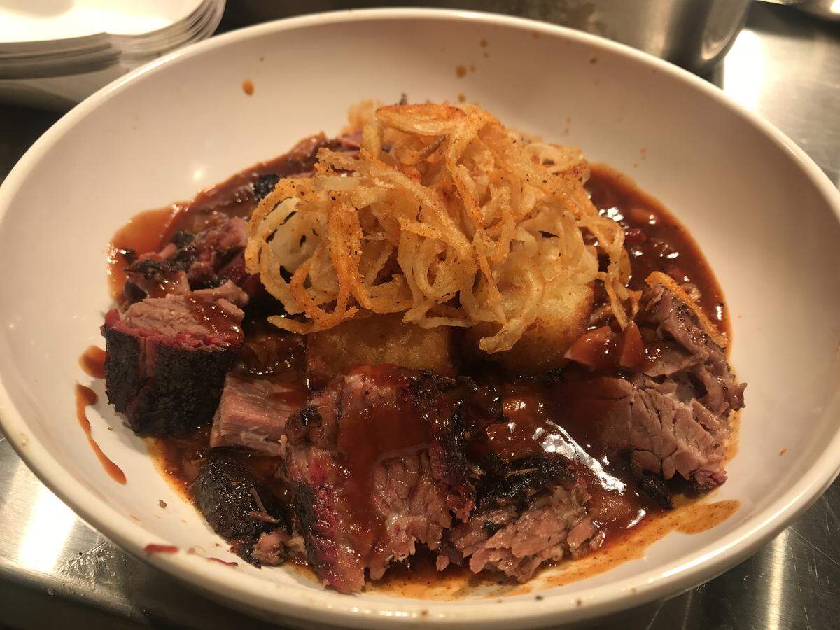Burnt End BBQ’s signature Burnt End Bowls with burnt ends, beans and cornbread croutons topped with crispy onion straws.
