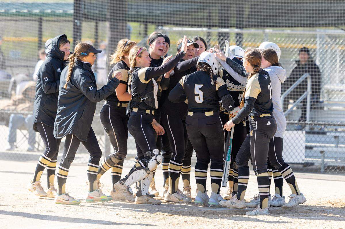 Teammates from the Nebraska Gold fast-pitch softball team celebrate during the 2023 Top Gun Invitational Tournament held in the Kansas City area.