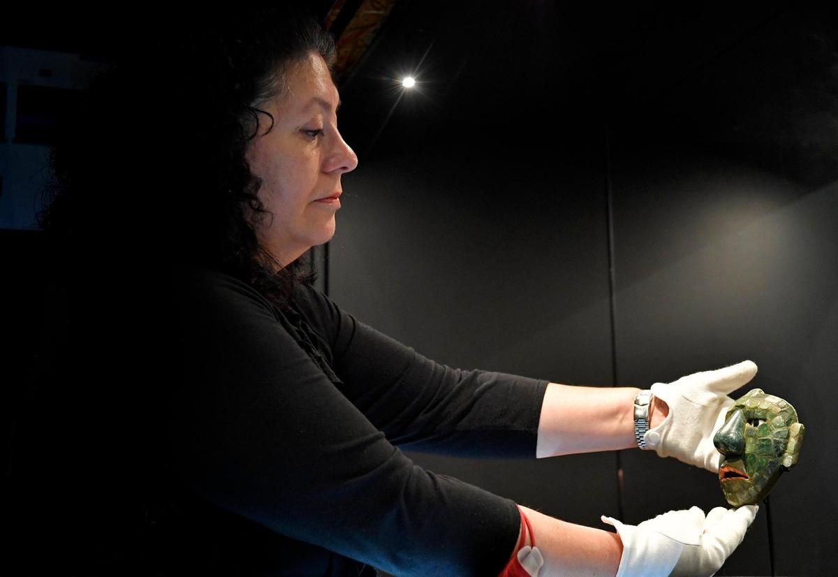 Sofia Paredes, director of La Ruta Maya Fundaceon in Guatemala City, and lead curator for the “Maya: The Great Jaguar Rises” exhibit, places a jade maskette in a display case at Union Station.