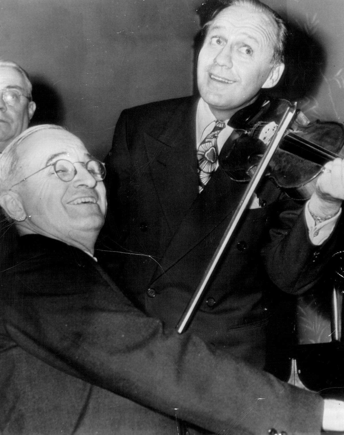 Vice President Harry S. Truman plays piano while comedian Jack Benny performs on violin at the National Press Club in 1945.