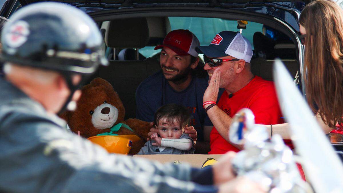 Tucker Langford, 3, sits with family in the back of an SUV on Saturday, Oct. 11, 2025. A parade honoring him while he battles terminal illness drew hundreds of participants.