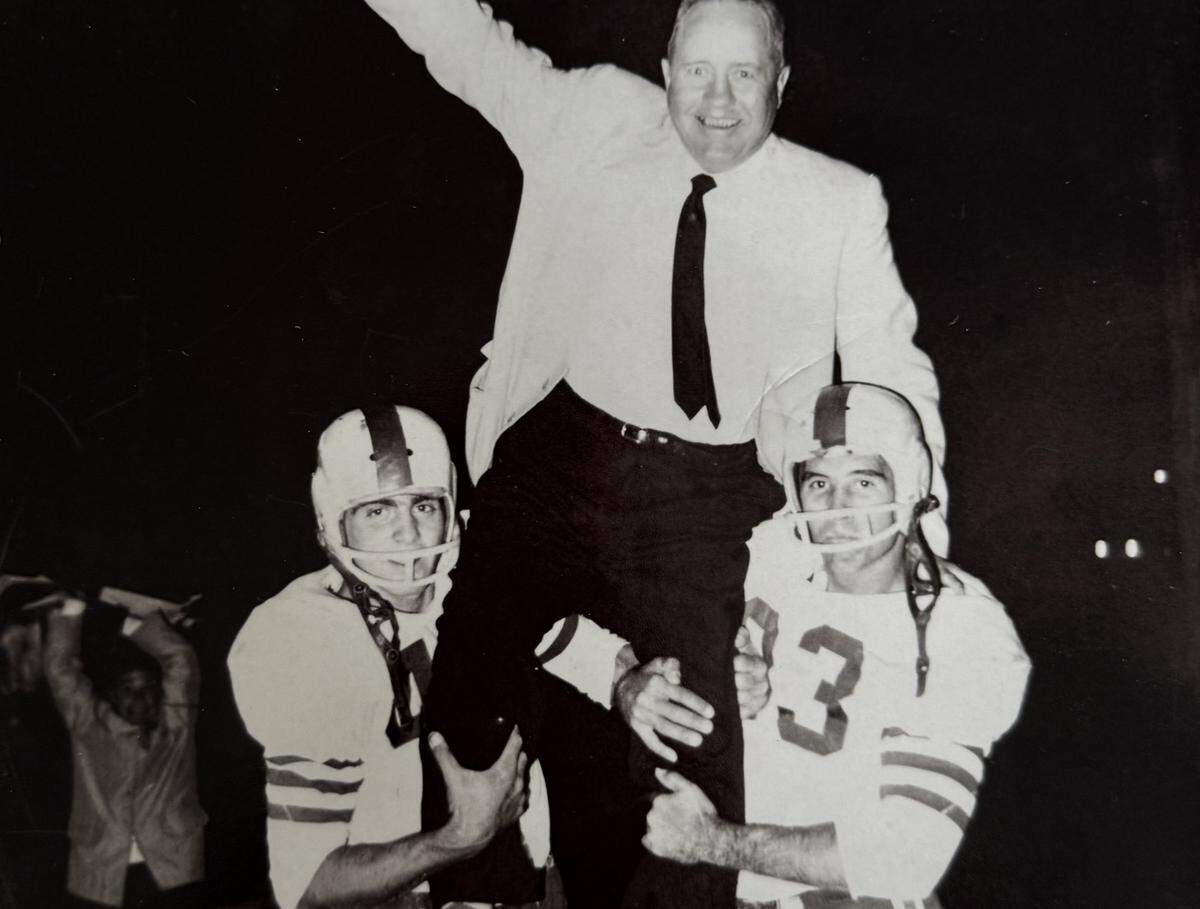 Bud Abell, left, and Roger Phillips lift coach Cecil Patterson after Southeast High School’s 52-0 win over Manual to finish a 9-0 season in 1958 in Kansas City.