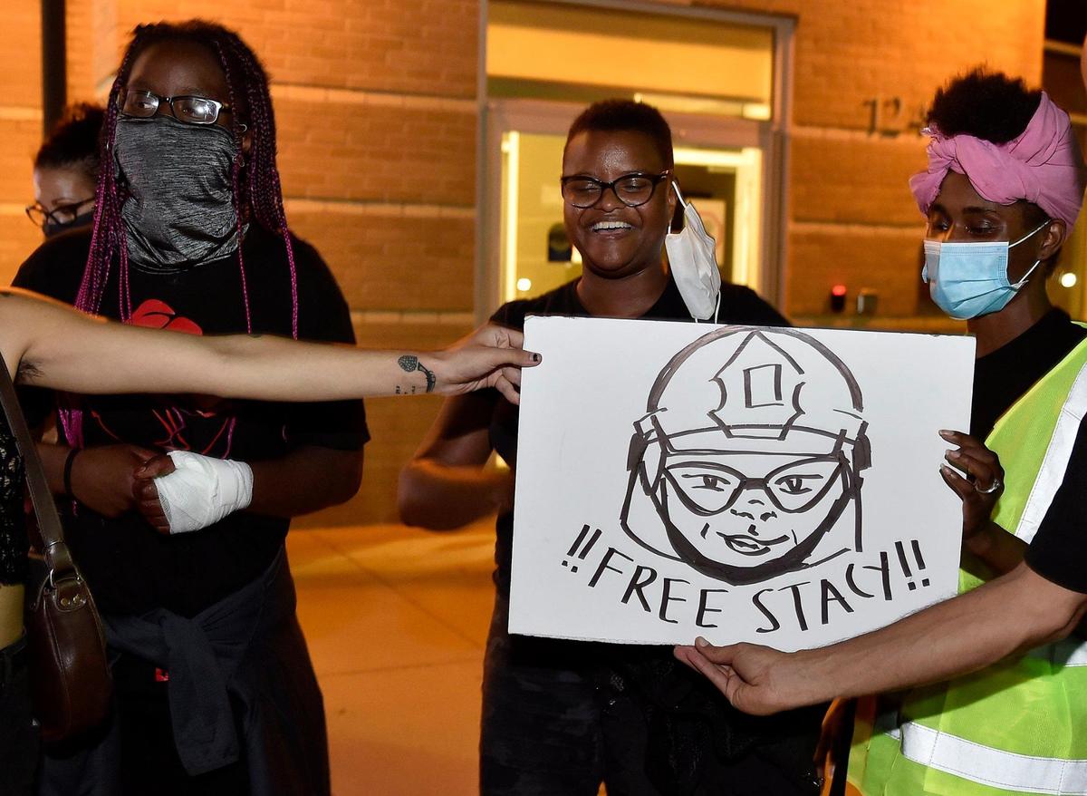 After four people were arrested during a march that began at Johnson County Community College and ended in a residential neighborhood in Overland Park, protesters waited in support at the W. Jack Sanders Justice Center Friday, July 24, 2020. Three were released that night. Attorney Stacy Shaw, center, and supporters held a poster after Shaw was released.