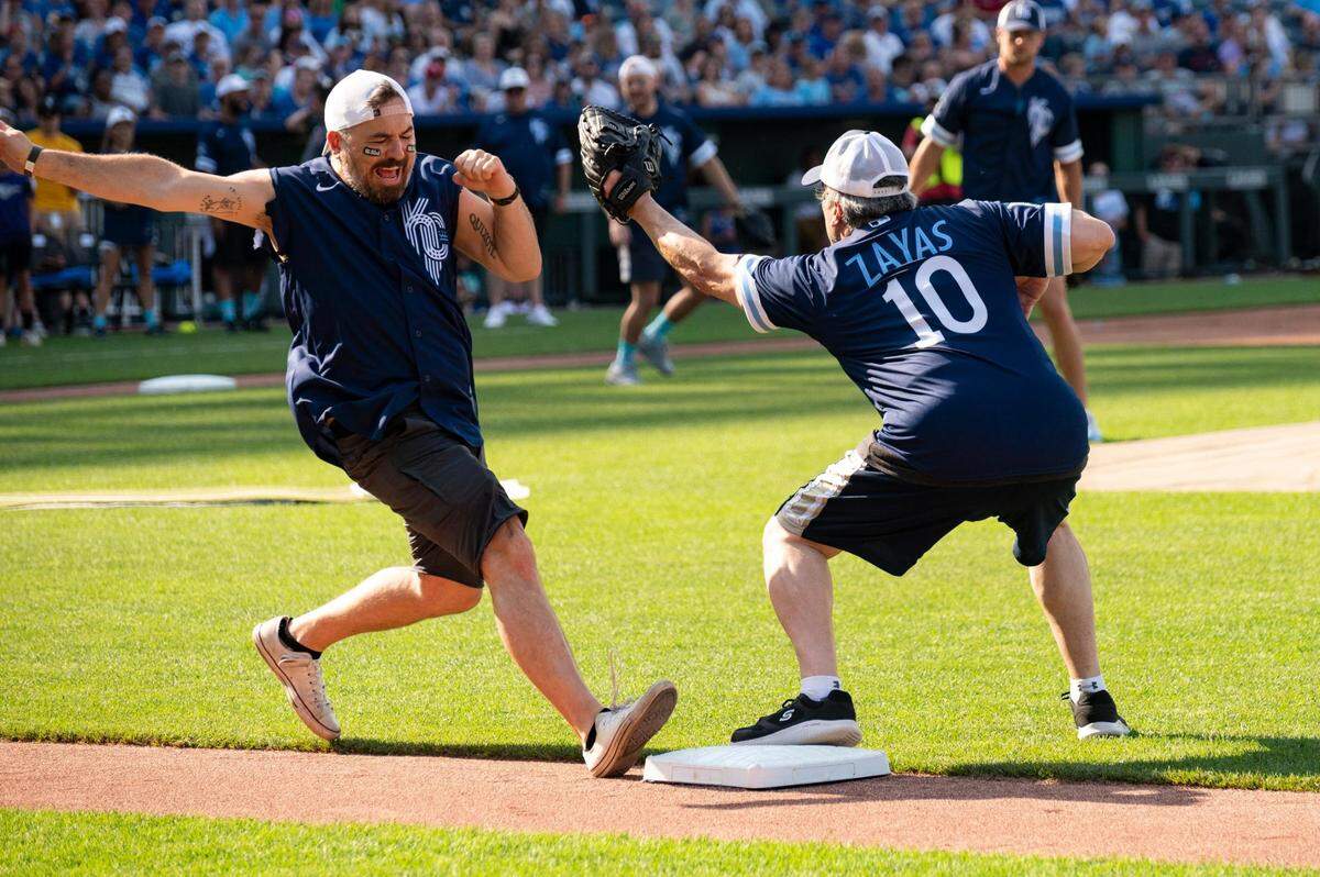 Brian Quinn of “Impractical Jokers” lunges for first base as David Zayas (“Dexter”) tries to tag him out during the Big Slick celebrity softball game at Kauffman Stadium Friday.