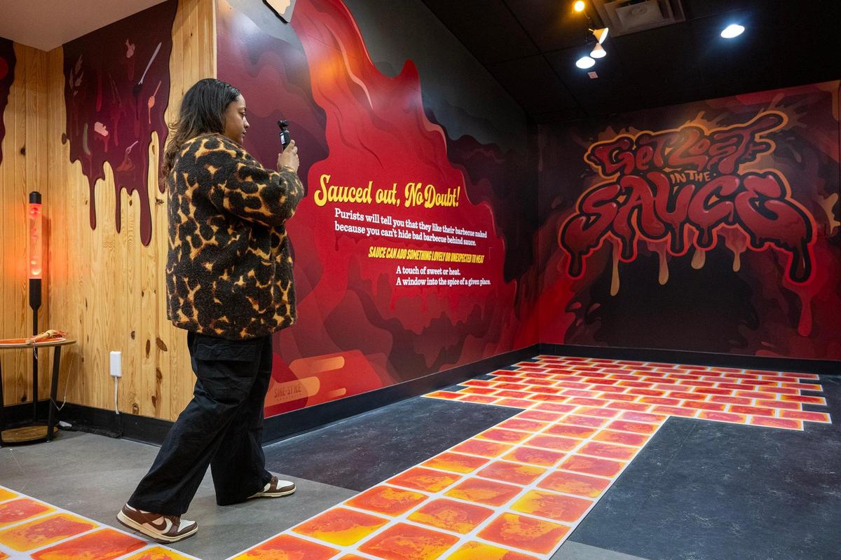 Jasmyn Franks, a content manager for VisitKC, tours the Sauce exhibit Wednesday at the new Museum of BBQ.