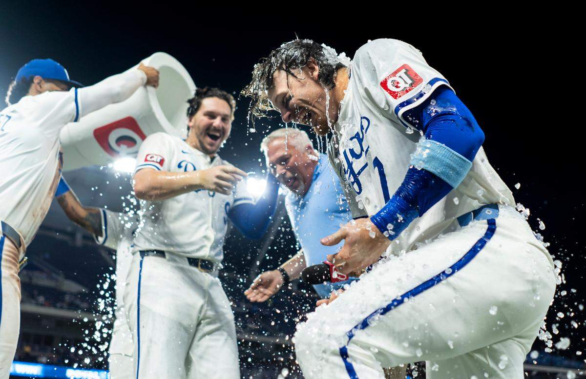 Kansas City Royals designated hitter Vinnie Pasquantino (9), shortstop Bobby Witt Jr. (7) and broadcaster Joel Goldberg are doused by first baseman Salvador Perez (13) and left fielder MJ Melendez (1) after defeating the Boston Red Sox at Kauffman Stadium on Aug. 7, 2024.
