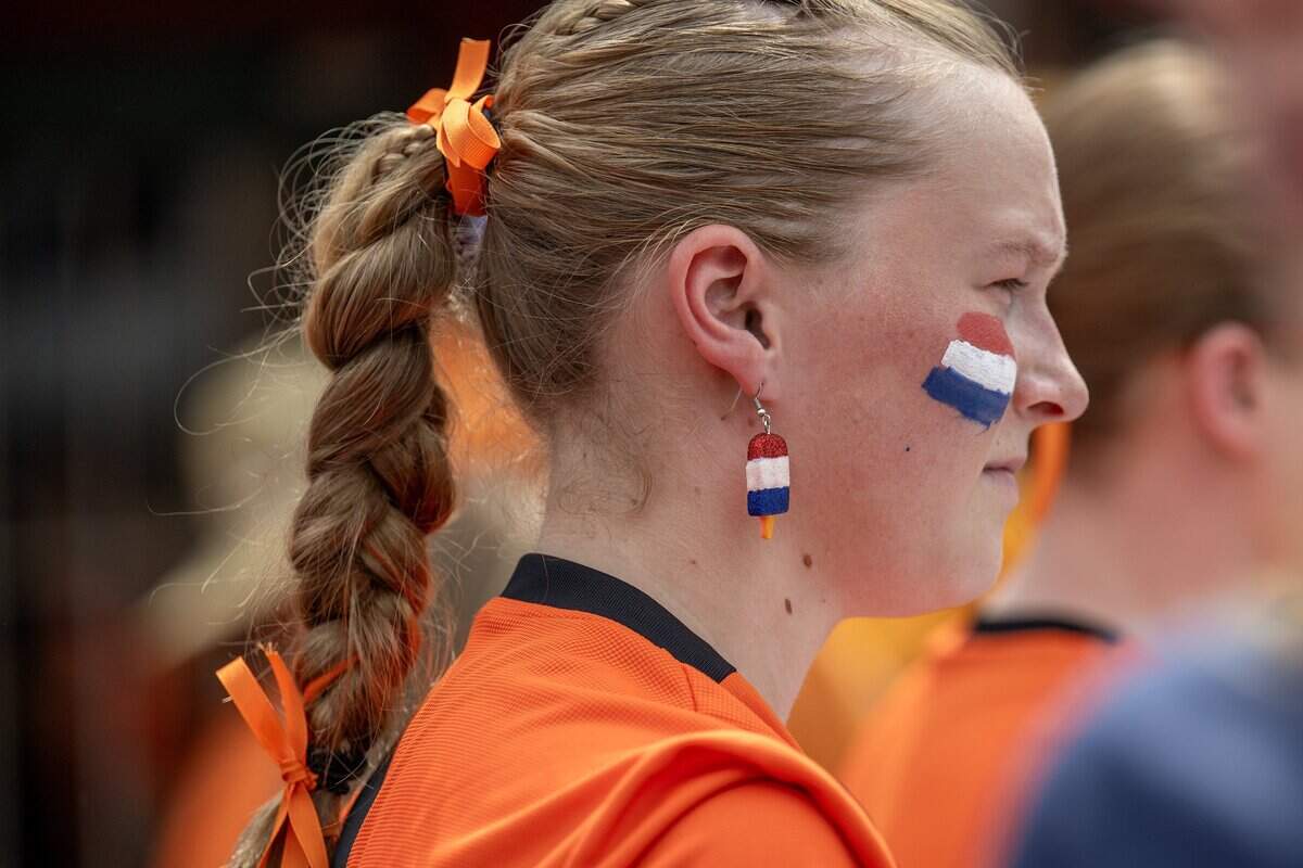 Dre Vandermeer, of Minnesota sports, Netherlands-themed ice cream earrings as she participates in the Orange Walk on Thursday, June 25, 2026, in Kansas City.