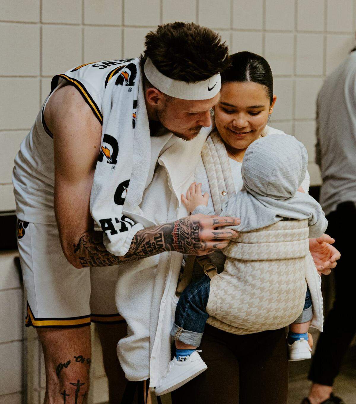 Mizzou’s Jacob Crews and his wife, Karmen, look adoringly at their son, JJ, before a game against Minnesota on Nov. 12 at Mizzou Arena in Columbia. Karmen and JJ attend the home games to show their support for Jacob.