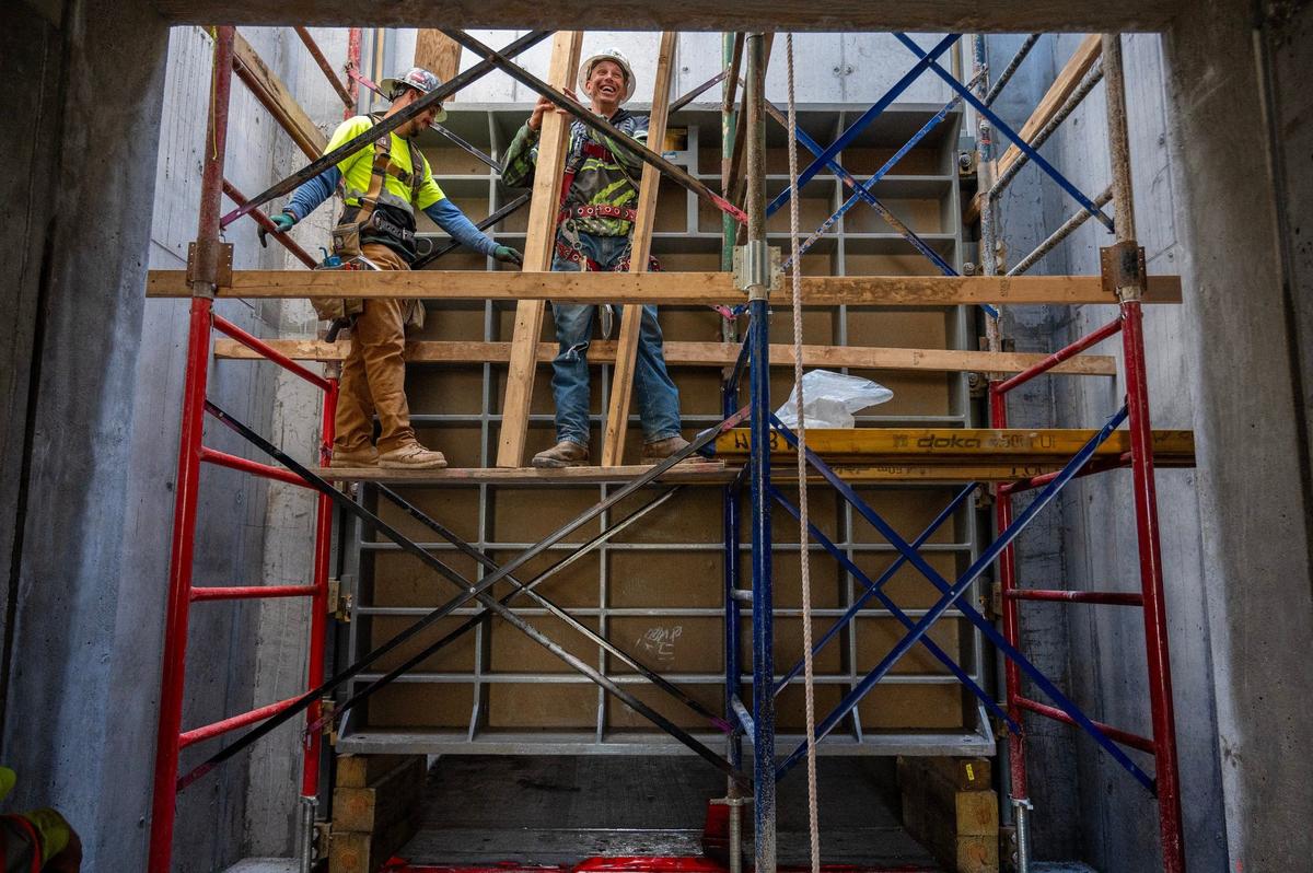 Construction workers install a sluice gate to control water flow at the Santa Fe Ditch construction site for the Kansas Citys Levee Project.