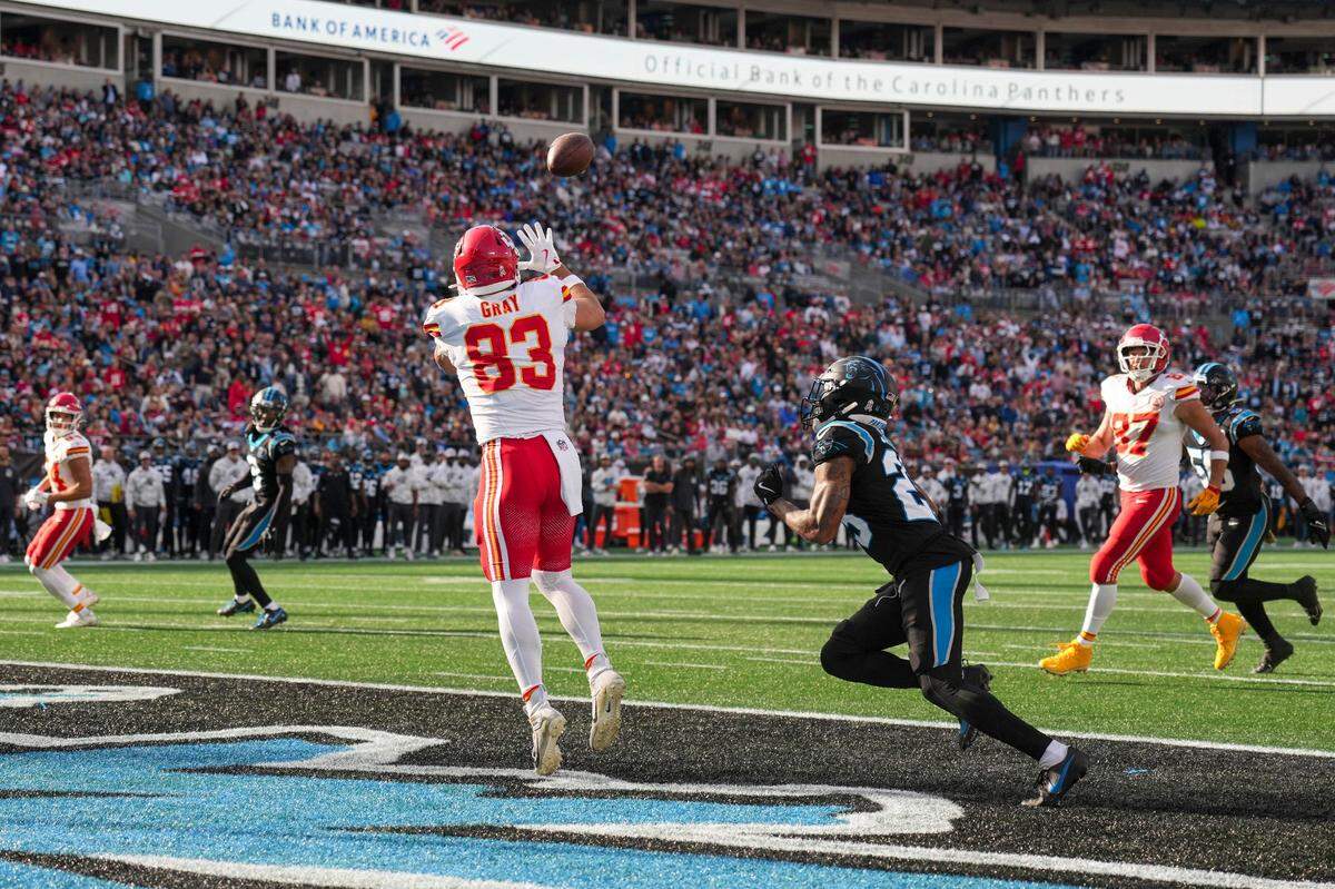 Kansas City Chiefs tight end Noah Gray (83) catches a touchdown pass guarded by Carolina Panthers safety Xavier Woods (25) during the second quarter at Bank of America Stadium.