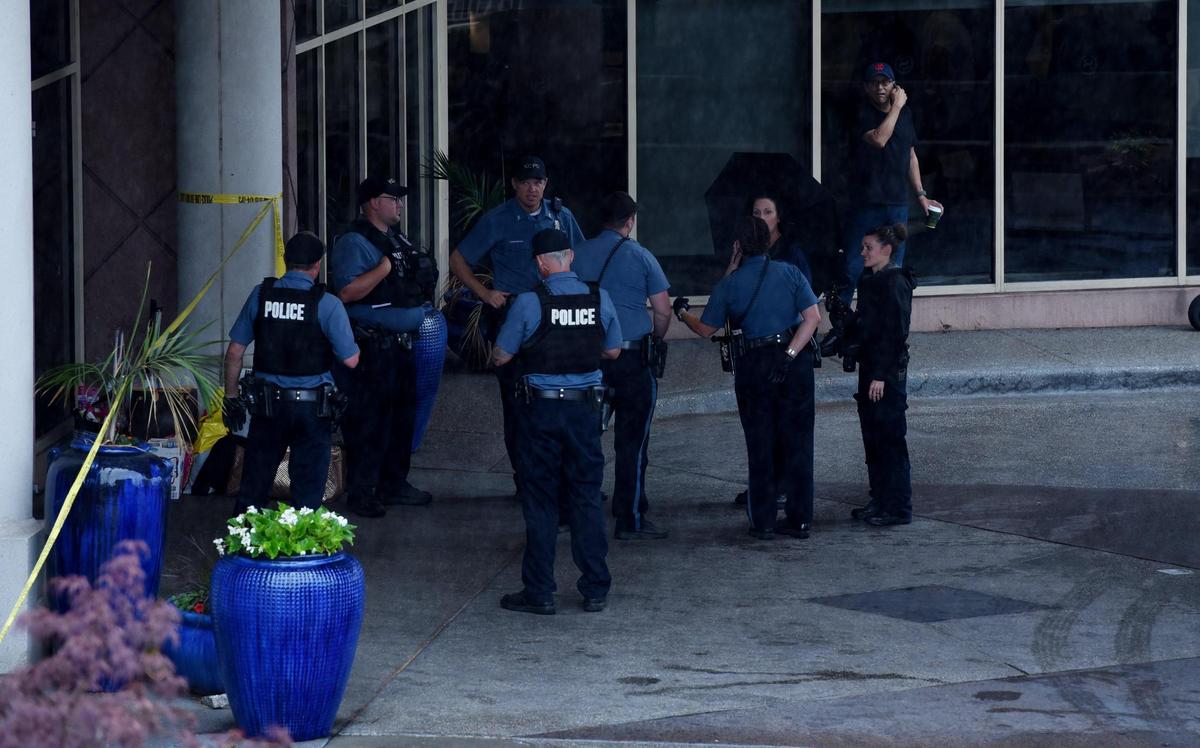 Kansas City police gather outside the front entrance to the Sheraton Suites hotel on the Country Club Plaza while working the scene of a shooting Tuesday morning at the hotel. One person was reportedly taken to a hospital in critical condition.