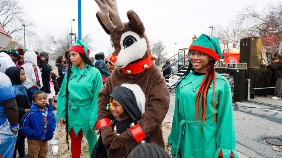 A previous year at Santa’s Wonderland with children gathered to take photos with Rudolph the Reindeer and volunteers dressed as holiday elves.