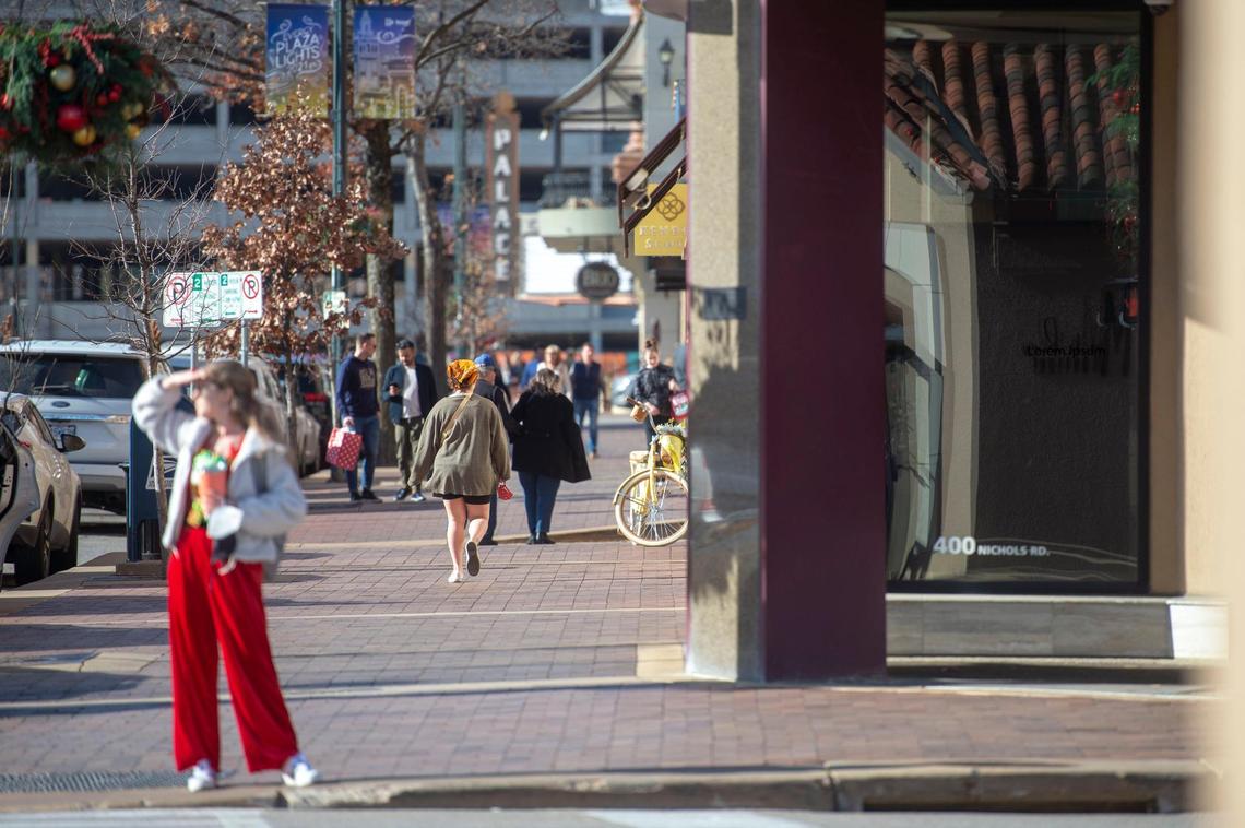 Holiday shoppers take advantage of the warm Christmas Eve weather to walk around the Country Club Plaza.