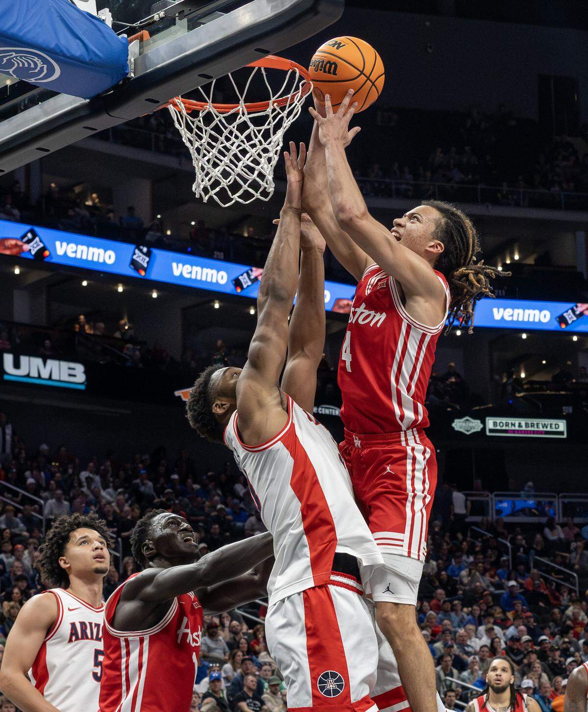 Houston Cougars guard Kingston Flemings (4) makes a layup over Arizona Wildcats forward Tobe Awaka (30) during the first half of the Big 12 Men's Basketball Tournament Championship game at T-Mobile Center on Saturday, March 14, 2026, in Kansas City.