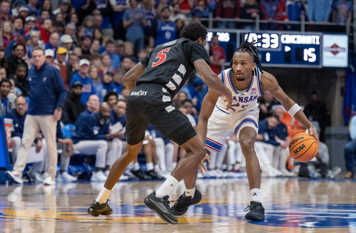 Kansas Jayhawks guard Darryn Peterson (22) dribbles in as Cincinnati Bearcats guard Sencire Harris (5) defends in the first half Allen Fieldhouse on Saturday, Feb. 21, 2026, in Lawrence, Kansas.