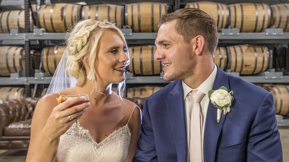 Samantha Kannawin and her groom, Jake Hammer, relax between wedding group photos in the barrel room of the Union Horse Distillery in Lenexa.