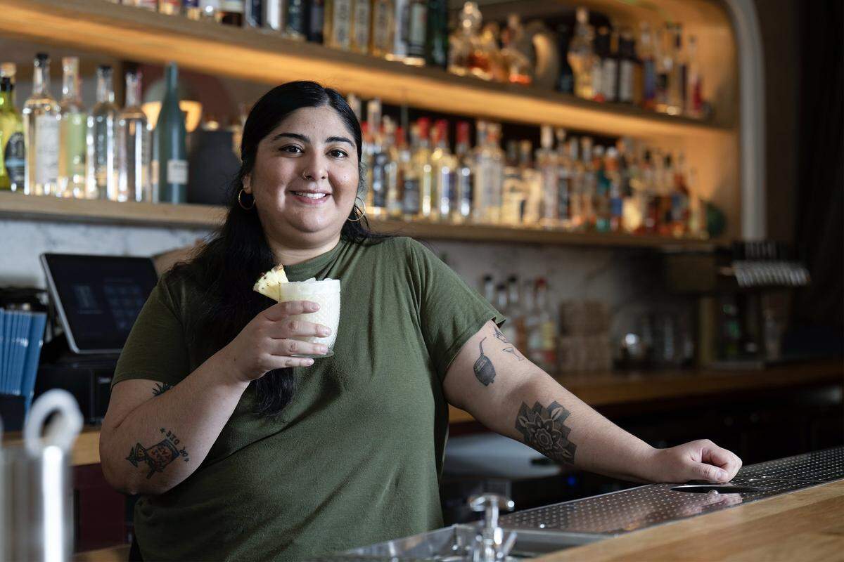 Diana Condori, a bartender at Fern Bar, with a Piña Colada on Thursday, March 5, 2026. The cocktail features a house rum blend, Clément Coconut, coconut cream, pineapple, and lime. Condori is a 2026 James Beard Award nominee for Outstanding Professional in Cocktail Service.