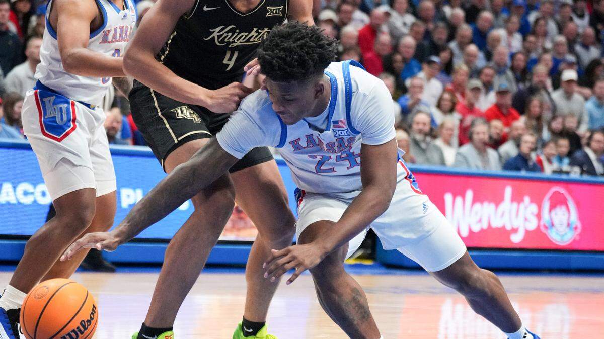Kansas Jayhawks forward KJ Adams (24) and UCF Knights guard Keyshawn Hall (4) fight for a loose ball during the first half at Allen Fieldhouse on Jan. 28, 2025.