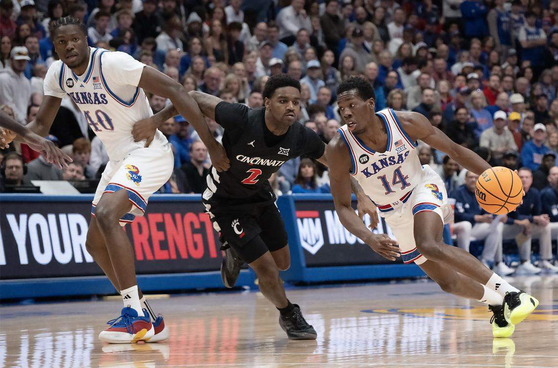 Kansas Jayhawks forward Flory Bidunga (40) looks on as guard Melvin Council Jr. (14) drives past Cincinnati Bearcats guard Jizzle James (2) in the first half Allen Fieldhouse on Saturday, Feb. 21, 2026, in Lawrence, Kansas.