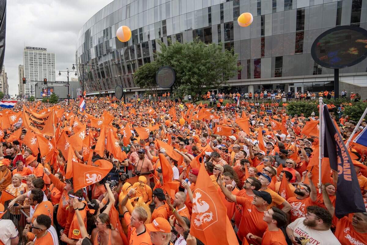 Fans wave Netherlands flags and toss beach balls as they celebrate near T-Mobile Center during the Orange Walk on Thursday, June 25, 2026, in Kansas City.