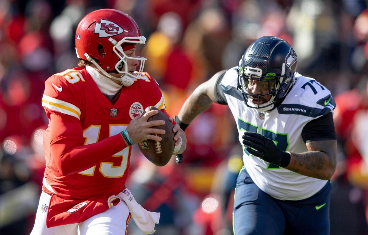 Kansas City Chiefs quarterback Patrick Mahomes (15) evades Seattle Seahawks defensive tackle Quinton Jefferson (77) during the first half of an NFL football game at Arrowhead Stadium on Saturday, Dec. 24, 2022, in Kansas City.