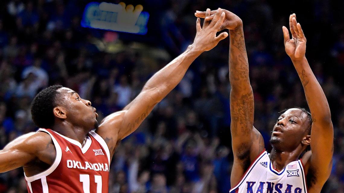 KU’s Marcus Garrett, who finished with 24 points, lets go of a three-pointer over OU’s De’Vion Harmon during the first half of Saturday’s game at Allen Fieldhouse. KU beat Oklahoma, 87-70.