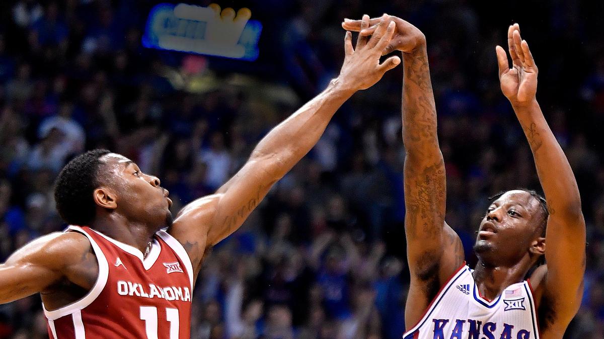 KU’s Marcus Garrett, who finished with 24 points, lets go of a three-pointer over OU’s De’Vion Harmon during the first half of Saturday’s game at Allen Fieldhouse. KU beat Oklahoma, 87-70.