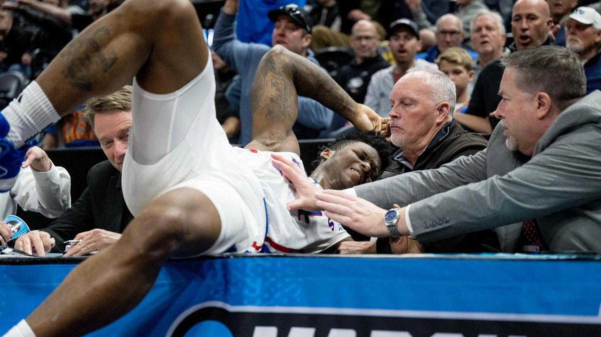 Kansas Jayhawks forward K.J. Adams (24) crashes into a sideline table during a men’s college basketball game against the Samford Bulldogs in the first round of the NCAA Tournament on Thursday, March 21, 2024, in Salt Lake City, Utah.