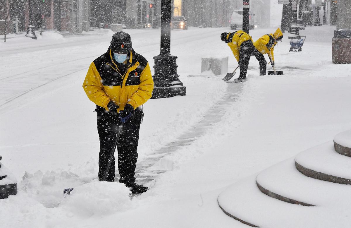 Snow continued to fall Wednesday morning over downtown Kansas City and the area as a major winter storm made its way across the plains states. Temperatures in the teens made things even more miserable for this crew clearing sidewalks at Main and 10th Streets. Forecasters called for up to a foot of snow with heavier amounts south of the metro area. Temperatures will dip below zero on Thursday night.
