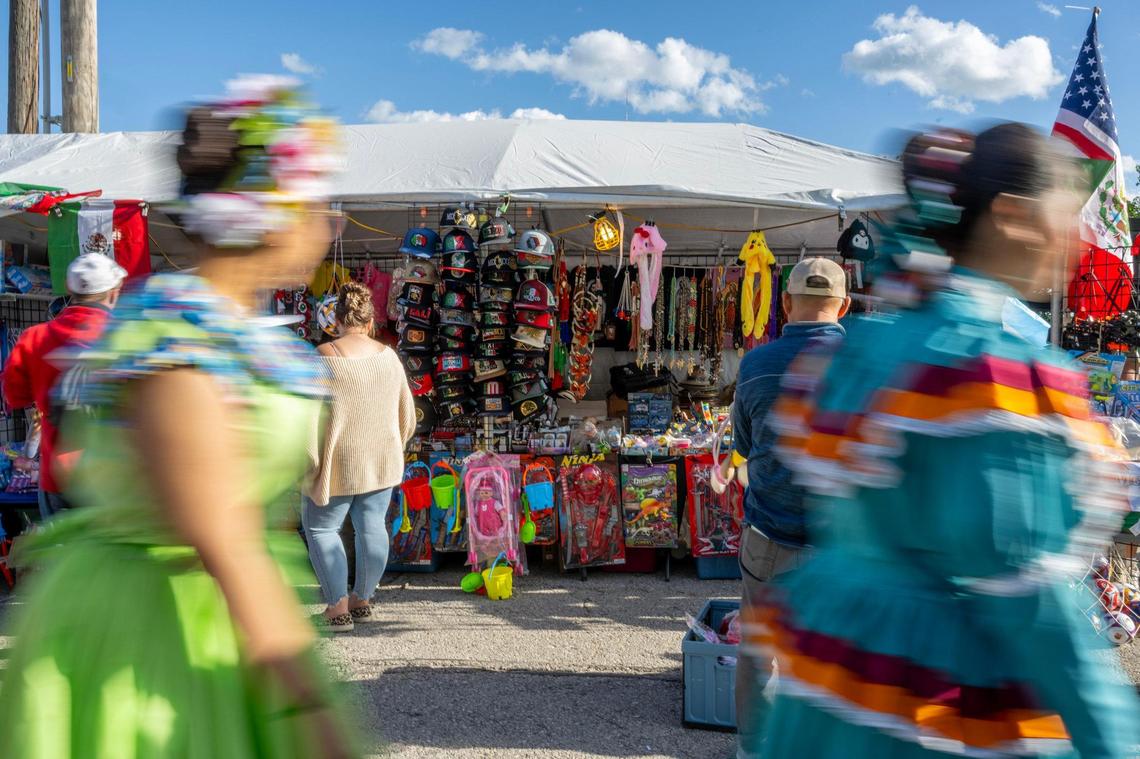 People walk past a booth filled with souvenirs during the Cinco de Mayo Festival at the Guadalupe Centers in Kansas City.