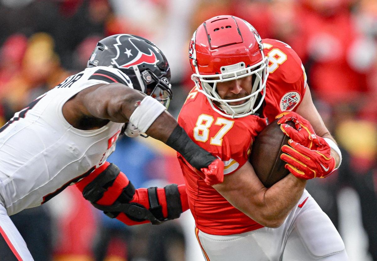Kansas City Chiefs tight end Travis Kelce (87) makes and catch and turns into the defense of Houston Texans linebacker Azeez Al-Shaair (0) in the second quarter during the AFC Divisional Round playoff game on Saturday, Jan. 18, 2025, at GEHA Field at Arrowhead Stadium.
