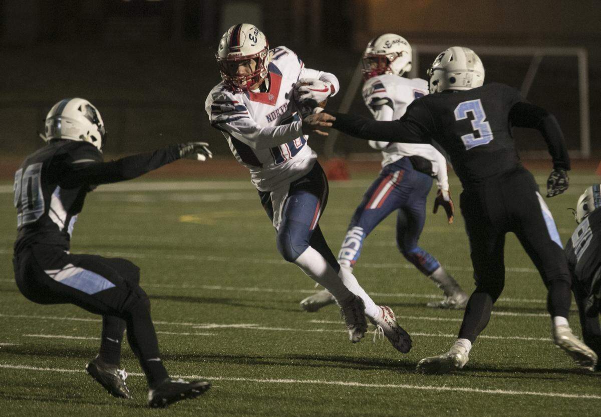 Olathe North quarterback Arland Bruce IV worked to burst up field against the Shawnee Mission East defense in Friday’s game at Shawnee Mission North.