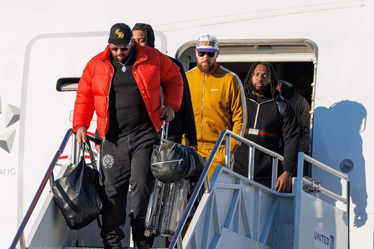 Kansas City Chiefs tight end Travis Kelce (middle) exits the plane after arriving at Louis Armstrong New Orleans International Airport on Feb. 2, 2025.