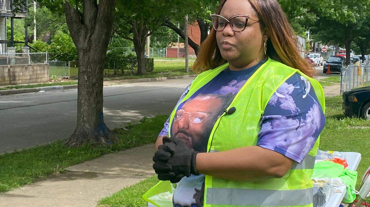 Myeisha Wright, 36, stands in front of her house on Saturday, May 28, 2022, during a neighborhood cleanup and block party. This year’s cleanup was organized in hopes of bringing attention to the 2021 killing of her younger brother, Tarey Johnson.