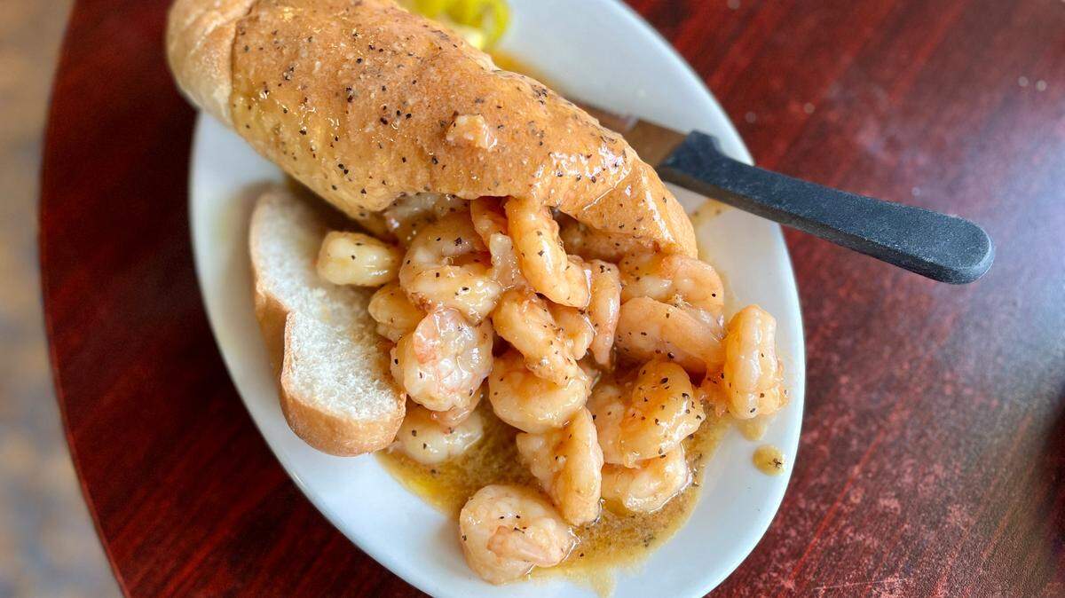 The Barbecue Shrimp Poboy is served on a loaf of hollowed-out New Orleans French bread overflowing with shrimp and sauce. A knife and fork is recommended.
