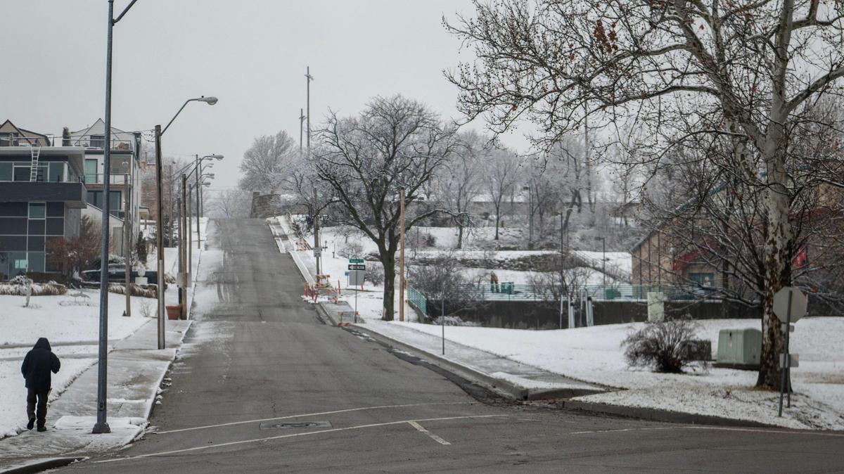 A pedestrian walks near the corners of West 21st Street and West Pennway Street during a light snow fall on Wednesday, Jan. 25, 2023, in Kansas City.