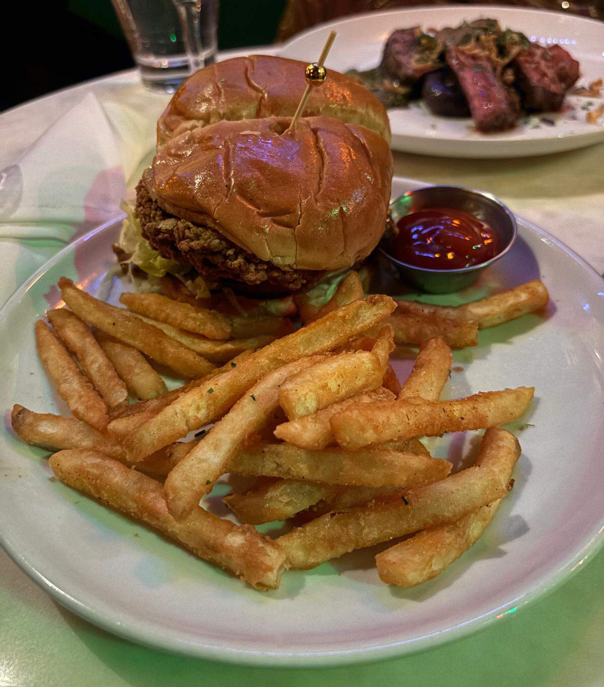 The fried chicken sandwich and fries are served at Tom’s Town in the Crossroads on Dec. 4, 2025.