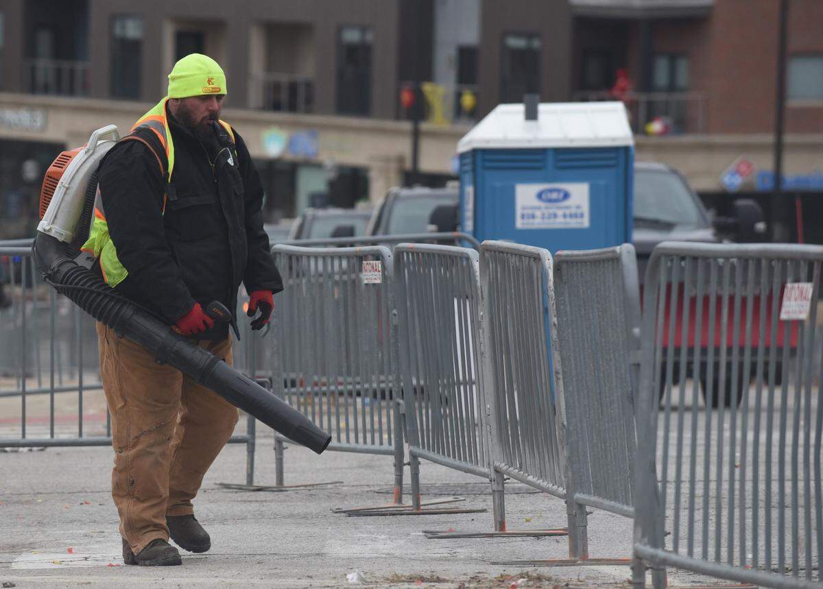 Jon Lee, a Kansas City employee, operates a leaf blower on Wednesday during the mass cleanup on Grand Boulevard following the Chiefs victory parade.