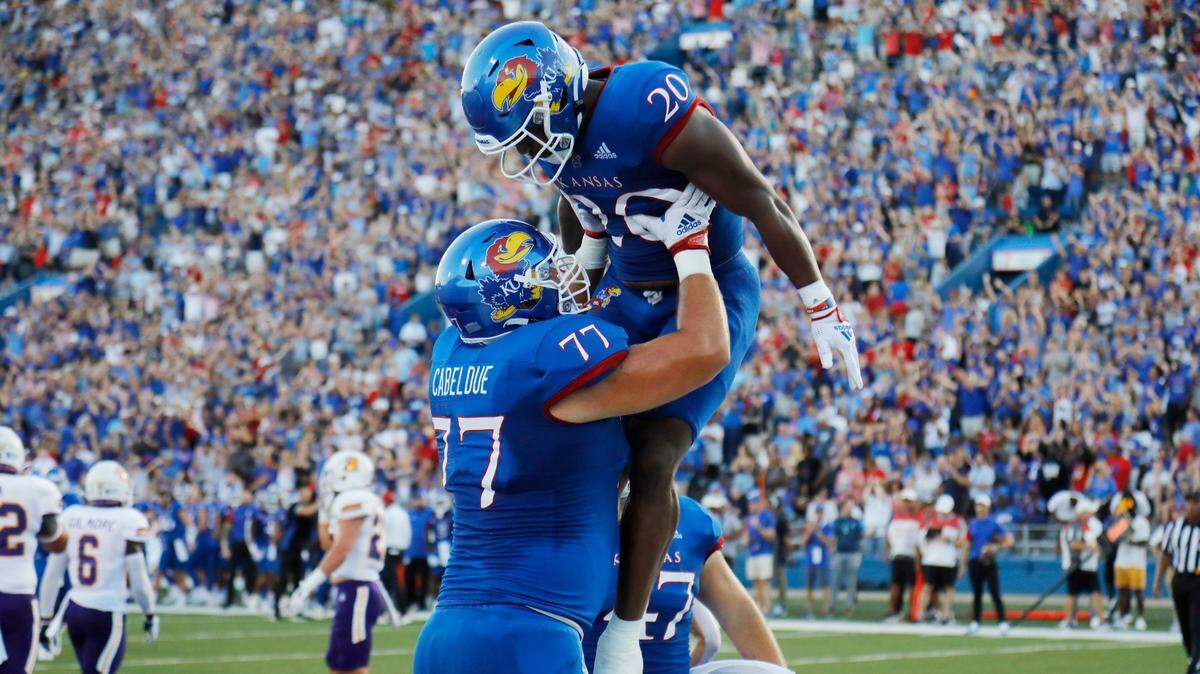 Kansas offensive lineman Bryce Cabeldue (left) lifts Kansas running back Daniel Hishaw Jr. after Hishaw ran the ball in for a touchdown against Tennessee Tech on Friday, Sept. 2, 2022 in Lawrence..