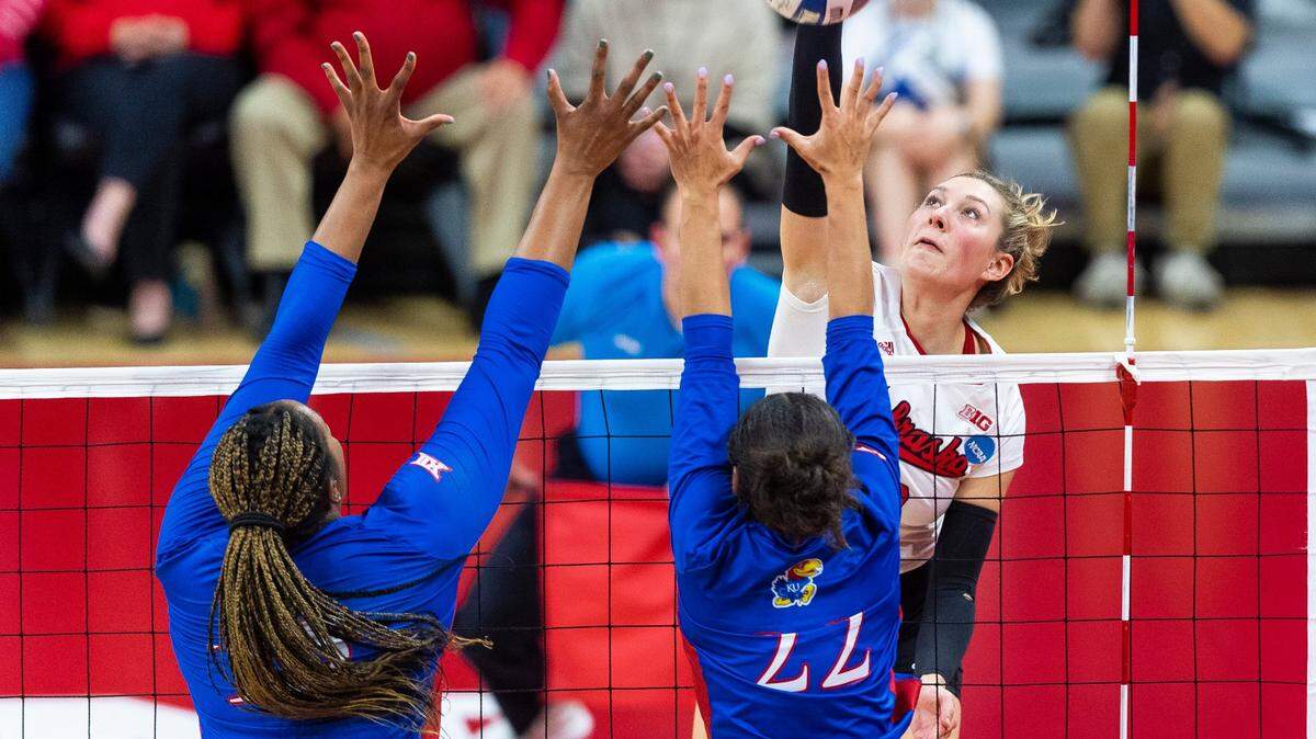 Nebraska’s Madi Kubik hits the ball over Kansas’ Camryn Turner and Bryn McGehe during a second round match of the NCAA college volleyball tournament on Dec. 2, 2022, in Lincoln.