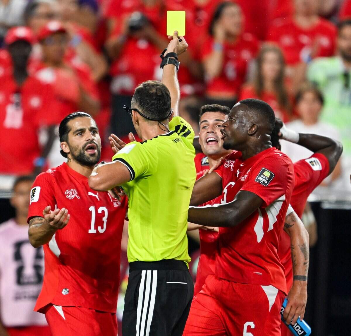 Swiss players argue with the official who penalizes Switzerland forward Breel Embolo (7) with his second yellow card of the match resulting in a red card and removing him from the Argentina vs. Switzerland 2026 World Cup Quarterfinal football match at Kansas City (Arrowhead) Stadium in Kansas City on Saturday, July 11, 2026.