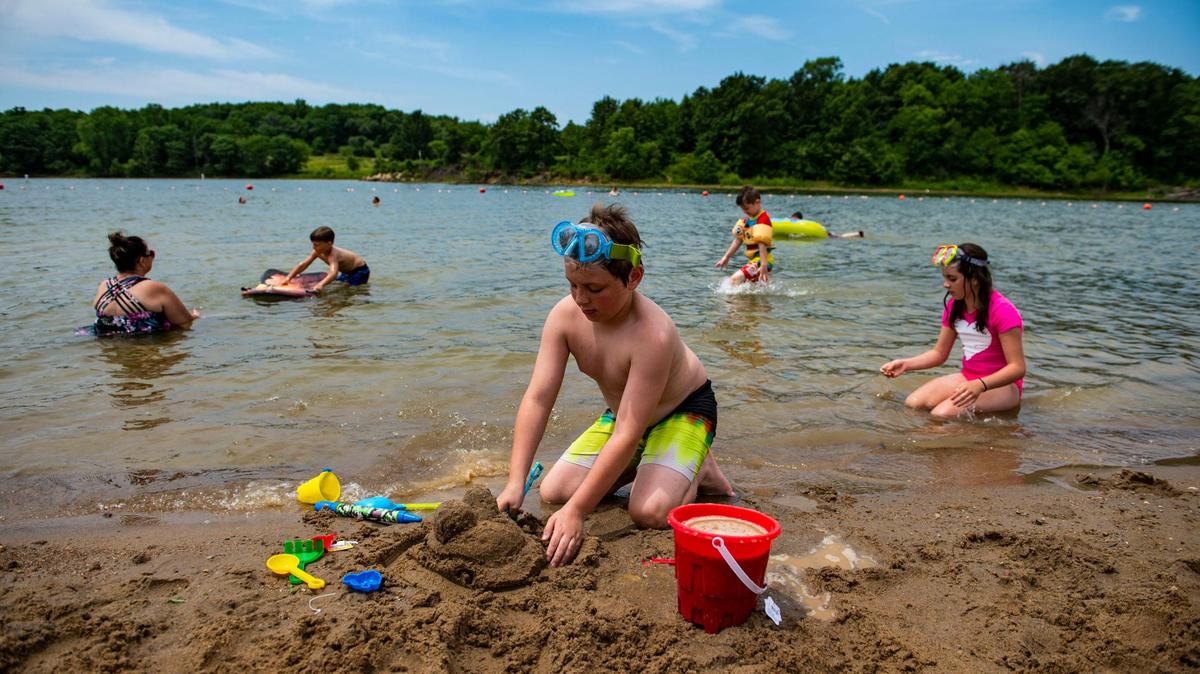 A child plays in the sand at Smithville Lake’s Little Platte Beach in June 2021.