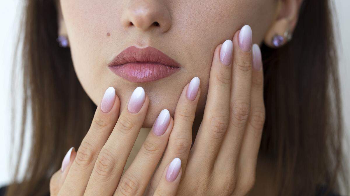 Beautiful woman’s nails with beautiful french manicure ombre peach and white