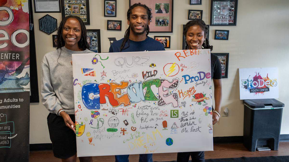 Alumni from Pro Deo youth center in Lee’s Summit show off their vision board they help create that will be placed in the new center once built. Pictured above from left to right is Chawnta’le Bushnell, Jarquez Brinkley and Ashanti Bushnell.