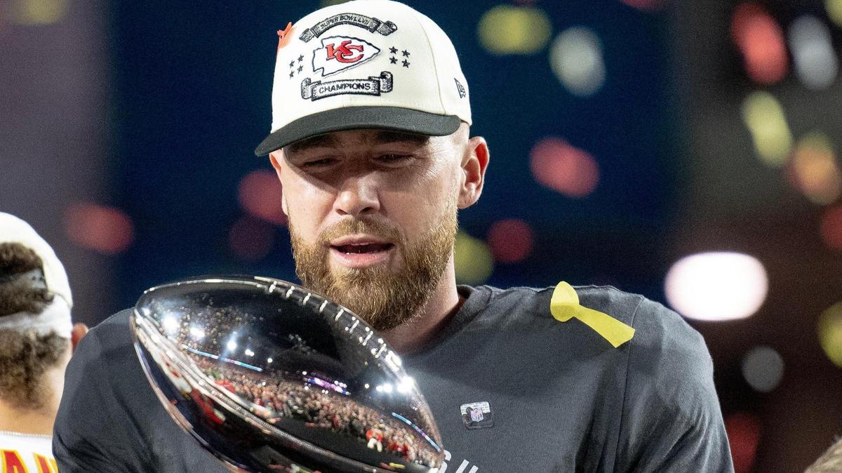 Kansas City Chiefs tight end Travis Kelce admires the Vince Lombardi Trophy after defeating the Philadelphia Eagles 38-35 in the Super Bowl LVII football game on Sunday, Feb. 12, 2023, in Glendale, Ariz.