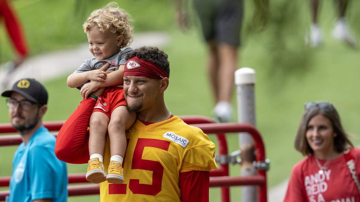 Kansas City Chiefs quarterback Patrick Mahomes (15) carries his son, Patrick "Bronze" Lavon Mahomes III at training camp at Missouri Western State University on Wednesday, July 30, 2025, in St. Joseph, Missouri.