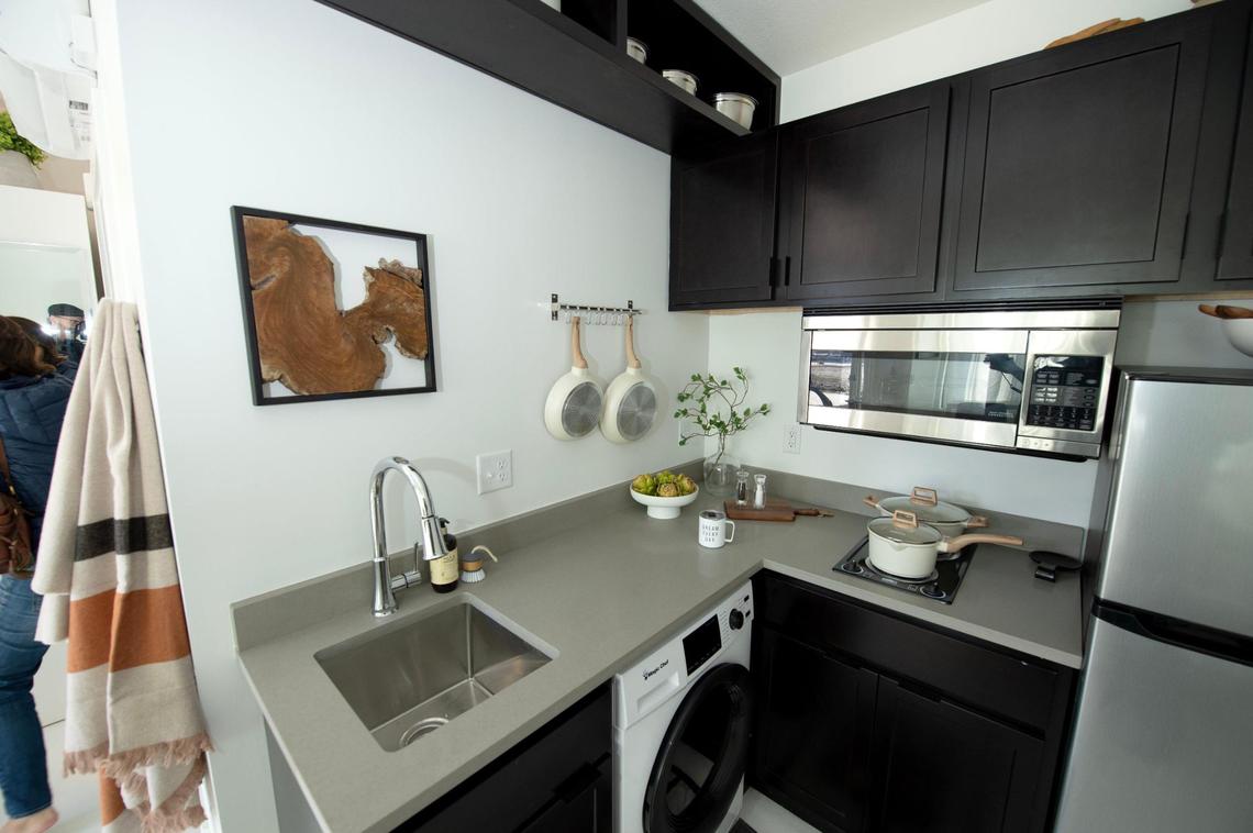 The kitchen area, with a two-burner stove and combination washer/dryer, inside the Signal Hill Studios made of steel shipping containers.