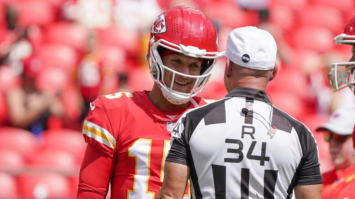 Kansas City Chiefs quarterback Patrick Mahomes (15) talks with referee Clete Blakeman (34) against the Washington Commanders prior to a preseason game at GEHA Field at Arrowhead Stadium.