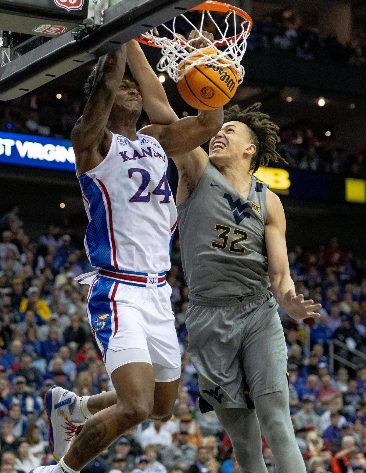 Kansas forward K.J. Adams Jr. (24) dunks the ball as West Virginia forward James Okonkwo (32) defends during an NCAA college basketball game in the second round of the Big 12 Conference tournament Thursday, March 9, 2023, in Kansas City.